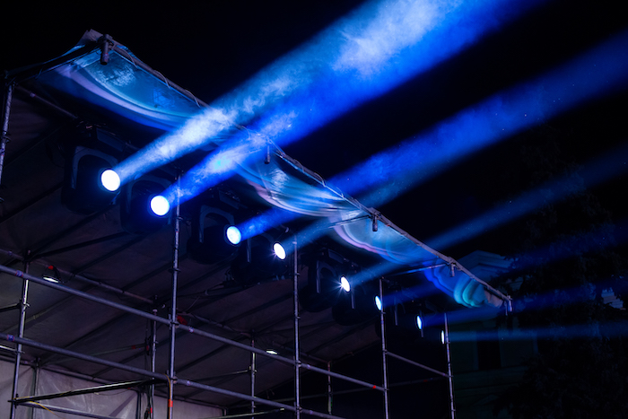 Stage lighting equipment in working condition at a concert. The moving head spot luminaire is mounted on a special construction.